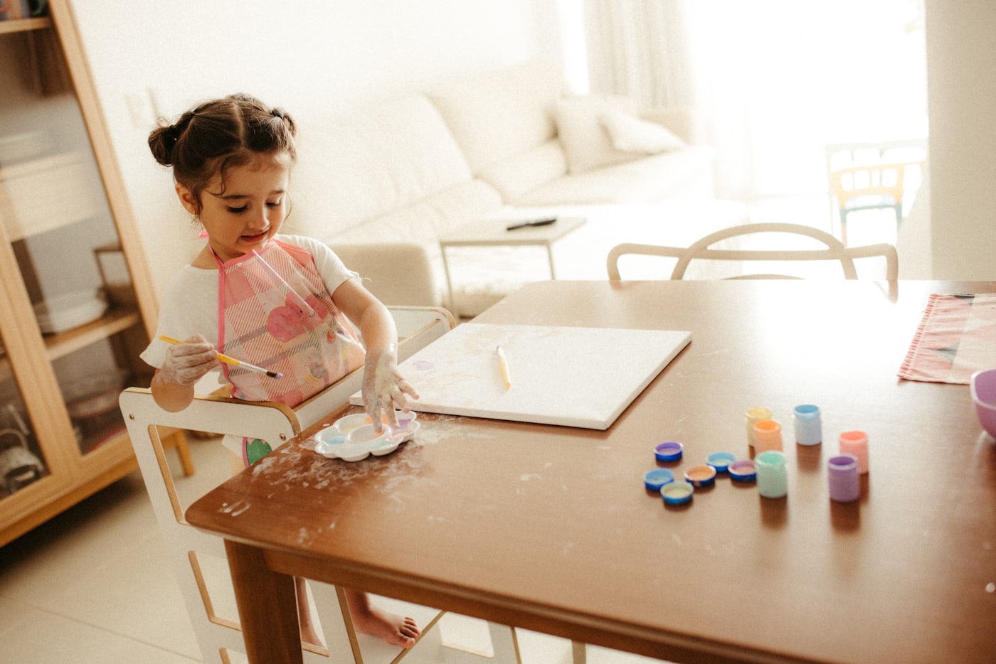 Young girl absorbed in painting at an art table
