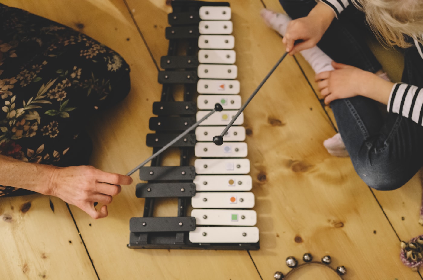Teacher and young student playing a musical instrument together