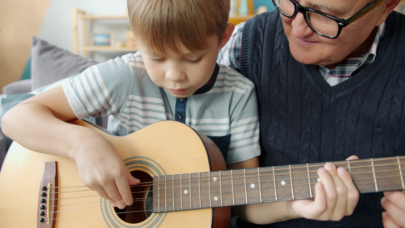 Mentor teaching a child guitar